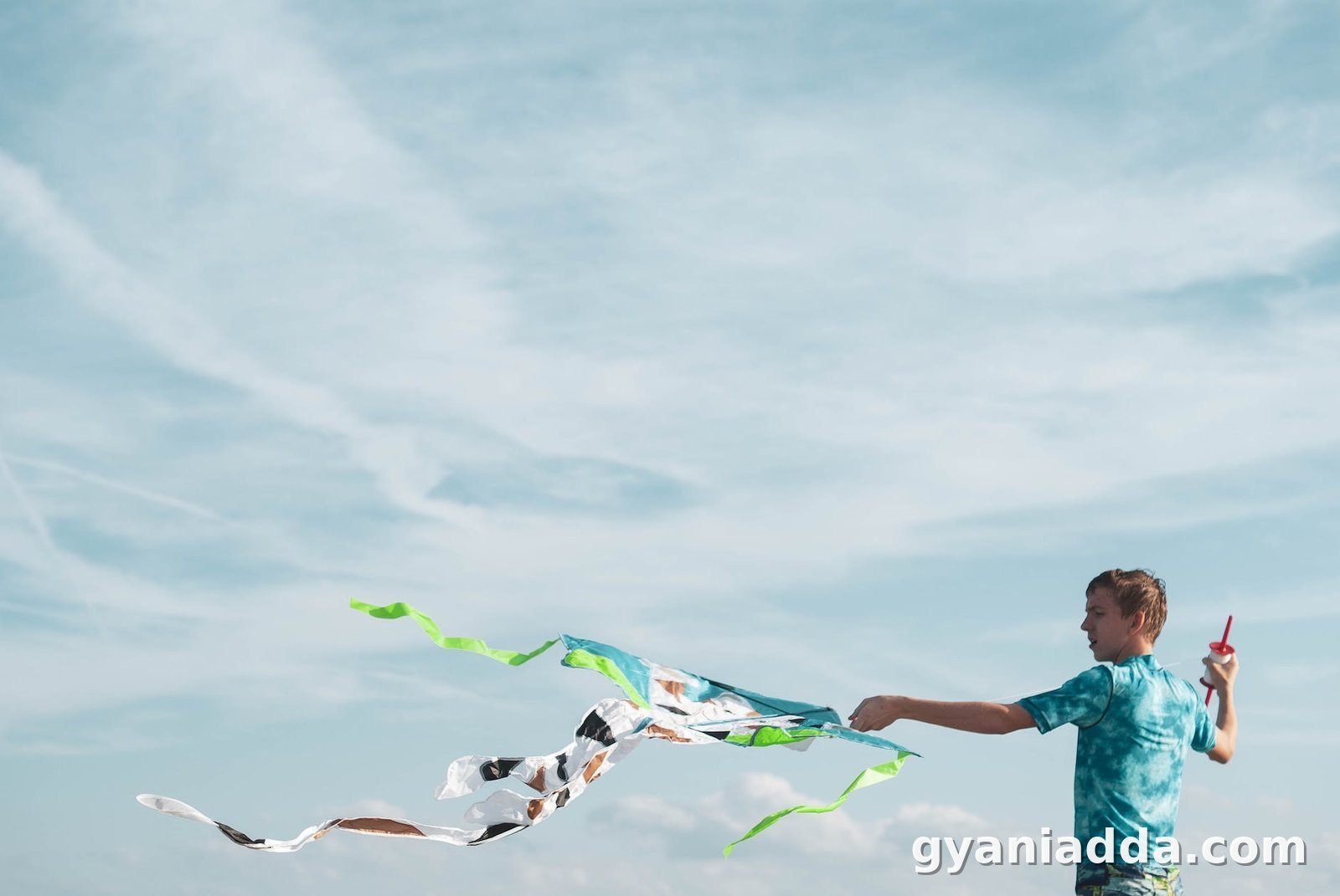 teenager with waving kite against sky